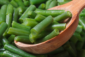 chopped green beans closeup on wooden spoon.