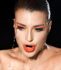 Fashion Girl Portrait. Makeup Orange Fluor under Flowing Water
