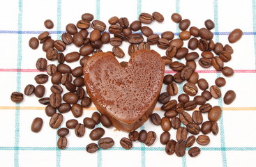 Heart shaped muffin with coffee grains on colorful cloth