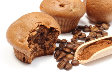Fresh baked muffins, coffee grains and powdery cinnamon
