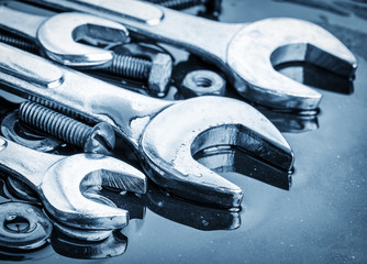 Set of tools wrenches and bolts toned in blue with reflections - obrazy, fototapety, plakaty