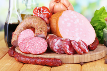 Different sausages on wooden table on natural background