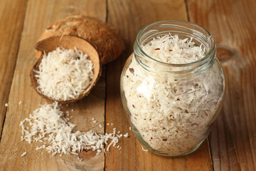 Homemade coconut shavings in coconut shell and glass jar