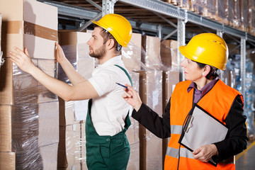 Manager with worker in warehouse