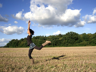 junge Frau springt in einem Feld