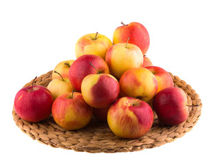 Red and yellow apples on a straw mat, isolated