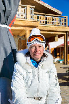 middle-aged woman in a white jacket and ski goggles
