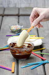 Preparing chocolate dipped banas dessert
