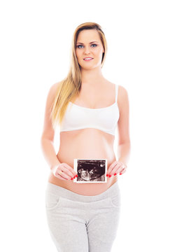 A pregnant blond woman holding an ultrasound