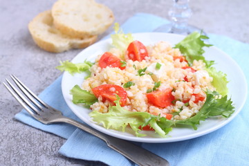 salad with tomatoes, feta cheese, grits and green