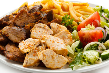 Grilled meat with French fries and vegetables