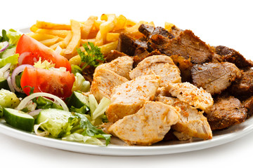 Grilled meat with French fries and vegetables