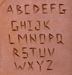 letters carved on clay