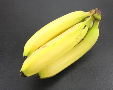 main de bananes sur plateau d'ardoise