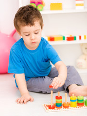 Fototapeta premium Boy is playing with building blocks