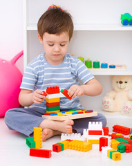 Boy is playing with building blocks