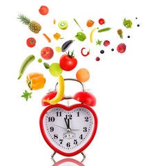 Clock in shape of heart with fruits and vegetables.