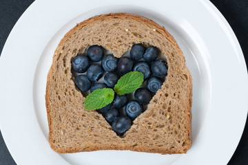 a piece of bread with the middle filled with fresh blueberries