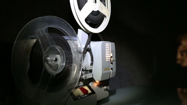 old projector showing film on screen - dolly shot