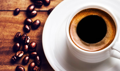 Coffee cup with roasted coffee beans  on wooden background, clos