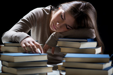 Tired student fell a sleep between many books