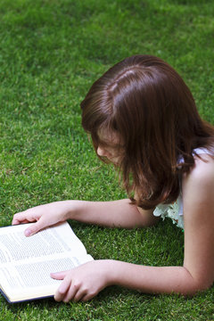 Tale.Young beautiful girl reading a book outdoor