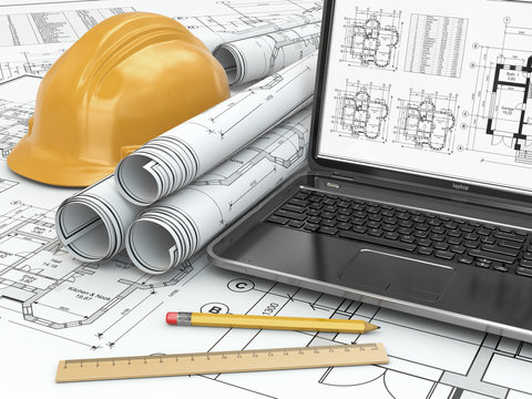 Laptop and blueprint with house project.