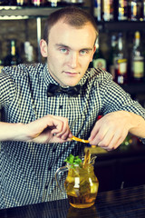 young man working as a bartender in a nightclub bar