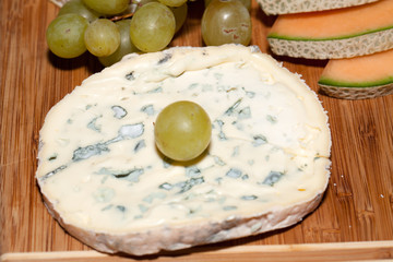Cheese with white grapes . Close up