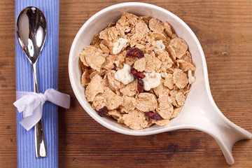 granola and fresh blueberries, in glass bowl over wood backgroun