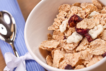 granola and fresh blueberries, in glass bowl over wood backgroun