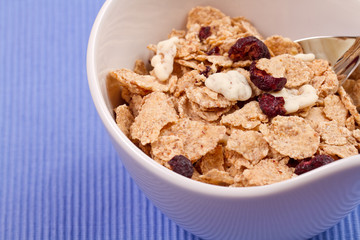 granola and fresh blueberries, in glass bowl over wood backgroun