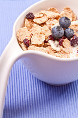 granola and fresh blueberries, in glass bowl over wood backgroun