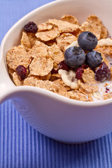 granola and fresh blueberries, in glass bowl over wood backgroun