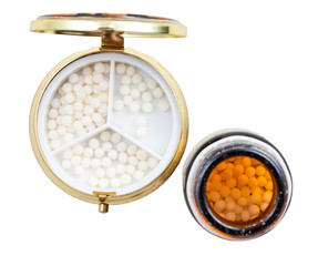pill box and glass jar with homeopathy sugar balls