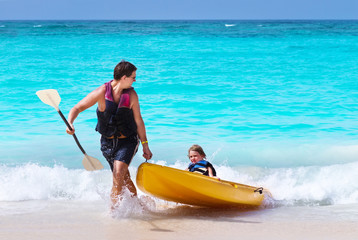 Father and son kayaking together on a tropical beach