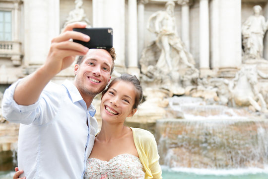 Tourist couple on travel in Rome by Trevi Fountain