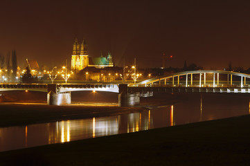 River Warta, bridge and cathedral at night in Poznan, Poland .