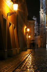 Rainy walk the cobbled street at night in Poznan .