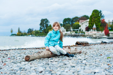 Outdoor portrait of a cute little girl next to lake