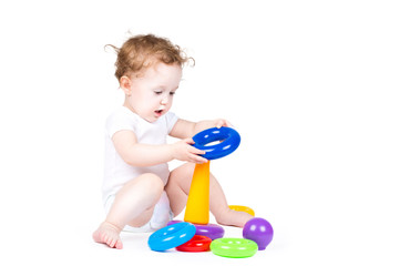 Funny baby playing with a colorful pyramid