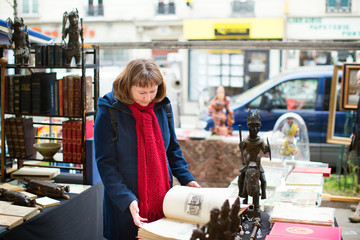 Girl selecting a book on a Parisian flea market
