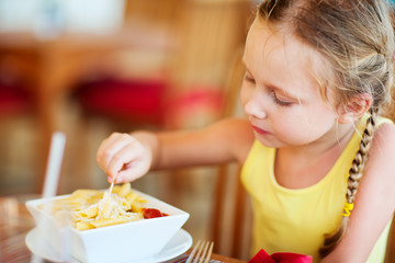Little girl eating pasta