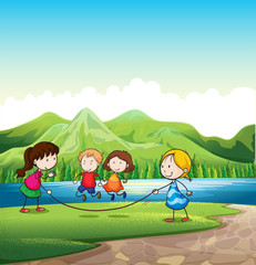 Obraz na płótnie Canvas Four kids playing with a rope near the river