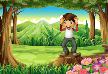 Obraz na płótnie Canvas A happy boy above the stump at the forest