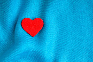 Valentine's day background. Red heart on blue folds cloth