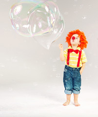Funny picture of little clown making soap bubbles