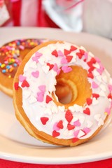 Two glazed donuts with multi-colored sprinkles