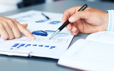 Unrecognizable business person analyzing graphs