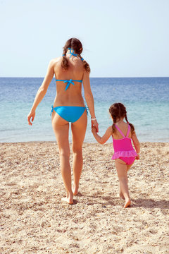 Mother and daughter on the sandy beach.